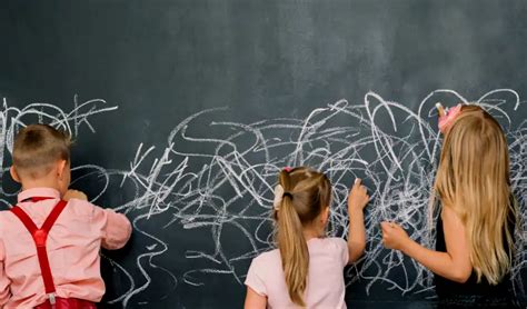 Dieťa kreslí na čiernu kriedovú tabuľu