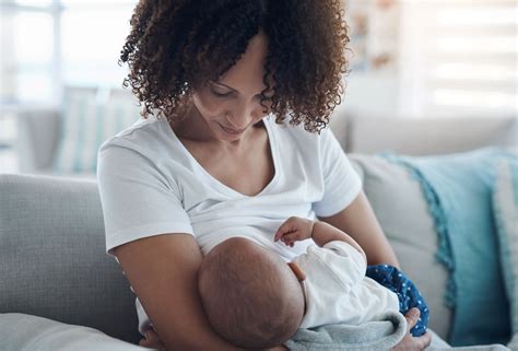 Woman breastfeeding baby while wearing a nursing nightgown