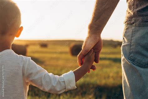 Thematic image: Parent holding child's hand in a park
