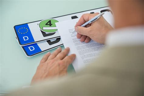 Pracovník dopravného inšpektorátu spracováva dokumenty k prepisu vozidla