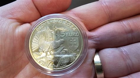 Strieborná minca s motívom bociana a bábätka