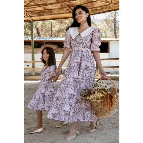 Matka s taškou prehodenou cez rameno v kombinácii s elegantným outfitom