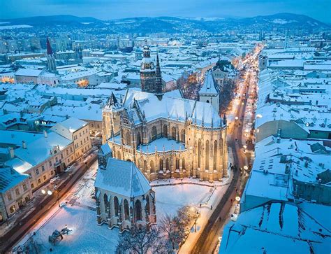 Zasnežené vianočné mesto s rozžiarenými ulicami