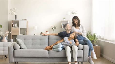 Žena oddychuje na gauči, zatiaľ čo jej partner sa hrá s dieťaťom