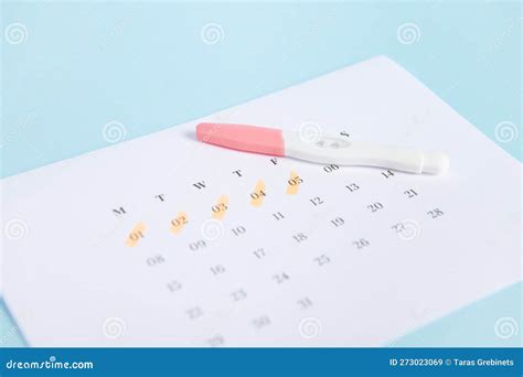 Calendar with marked dates and a pregnancy test
