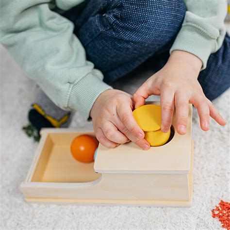 dieťa vkladá predmety do pripravenej Montessori krabičky