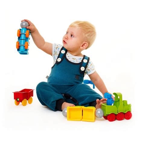 Dieťa sedí na podložke obklopené hračkami