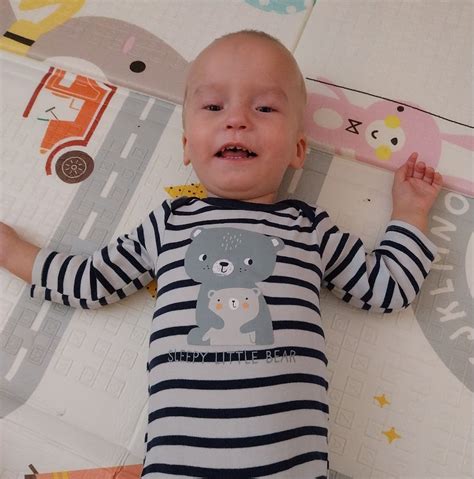 dieťa stojace rozkročmo nad motorkou, skúšajúce či dotiahne na zem
