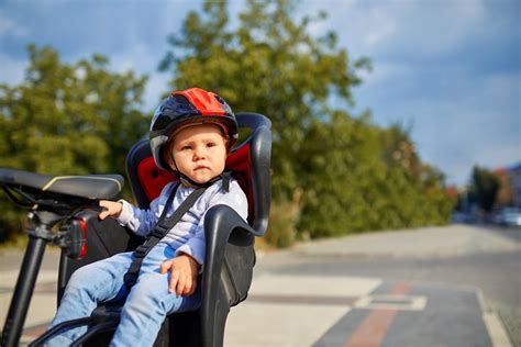 Dieťa s cyklistickou prilbou v detskej sedačke