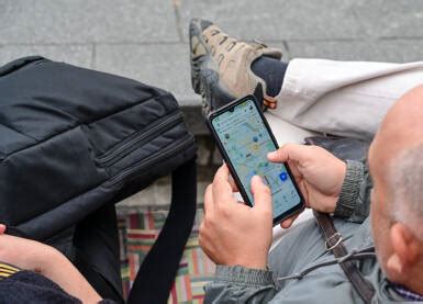 Turista kontroluje mapu a počasie na mobilnom telefóne v horách