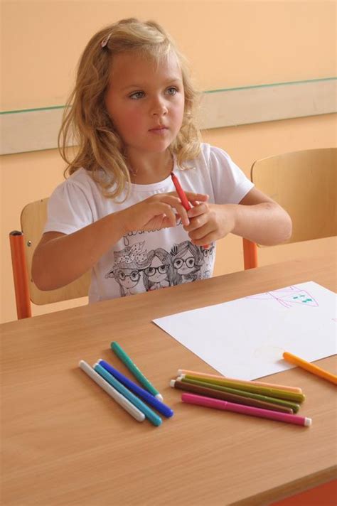 Ruky dieťaťa držiace pastelky