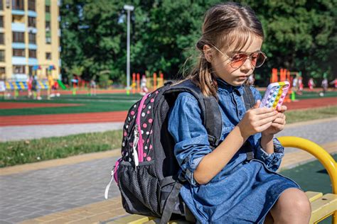 Dieťa s mobilom v školskej taške