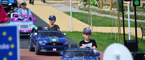 Deti jazdiace na elektrických autíčkach Peg Pérego v parku