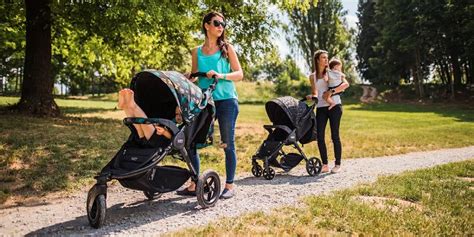 Rodič bežiaci s dieťaťom v športovom kočíku v parku