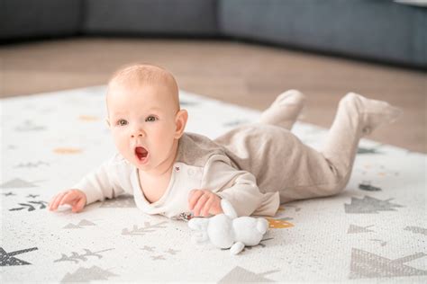 bábätko hrajúce sa na podložke
