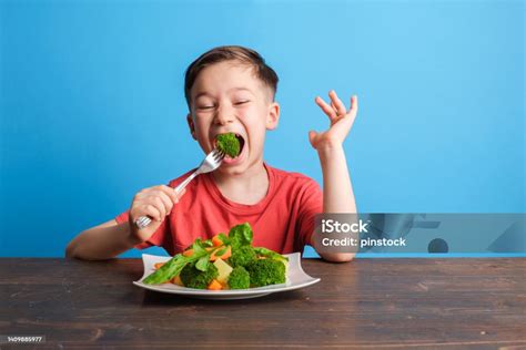 Happy child eating vegetables
