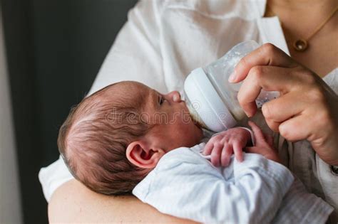 Mother comforting baby after bottle feeding