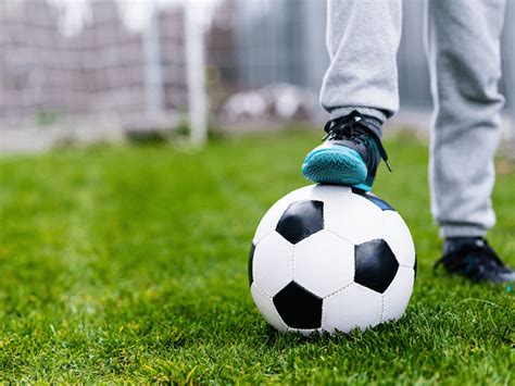 Dieťa s futbalovou loptou a rodičmi na ihrisku