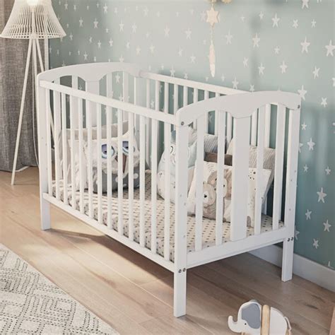 biela drevená postieľka s obrázkami