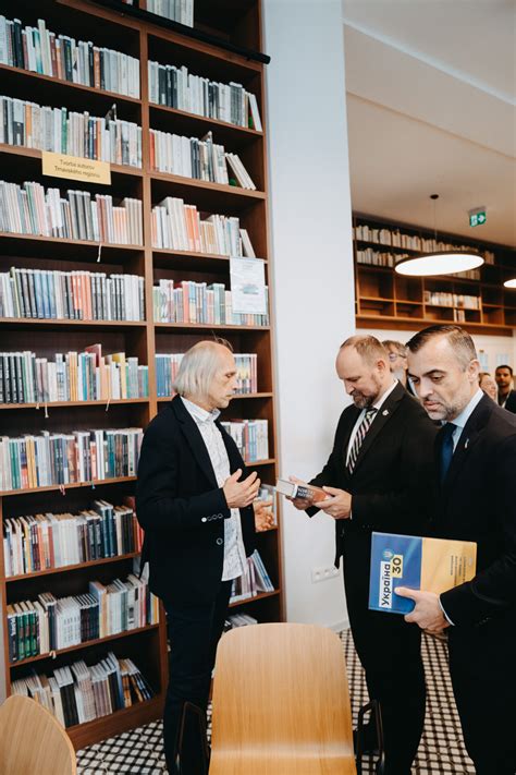 Študent v knižnici, obklopený knihami a so záujmom o poznanie