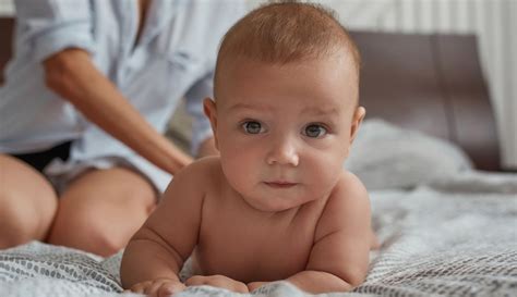 Dieťa hrajúce sa na brušku na podložke.