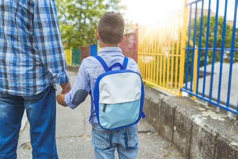 rodič objíma dieťa pred bránou škôlky