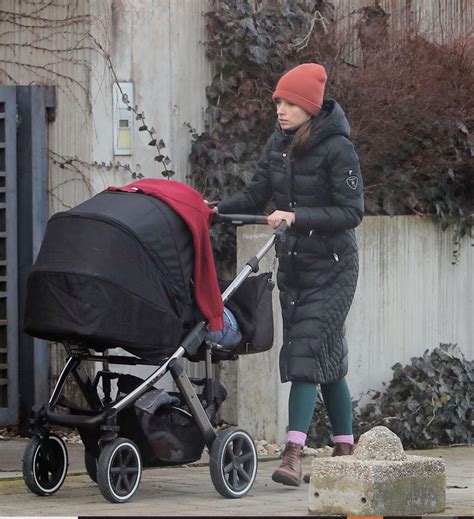 Dieťa na stúpadle za kočíkom, šťastne sa veziace