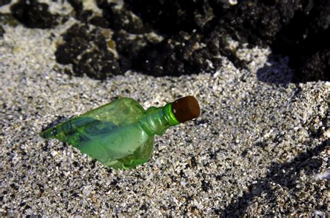 fľaša s odkazom v piesku na morskom pobreží
