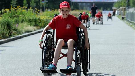 žena na invalidnom vozíku držiac v náručí dieťa