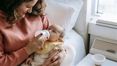 dieťa pije z fľaše s lyžičkou