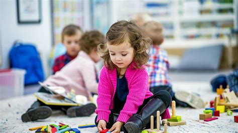 Dieťa s okuliarmi sa hrá s hračkami