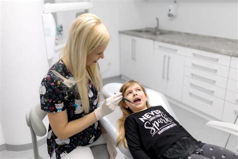 Zubný lekár vyšetrujúci dieťa technikou 