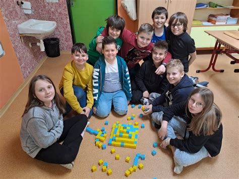 Deti si navzájom pomáhajú pri stavaní veže z kociek