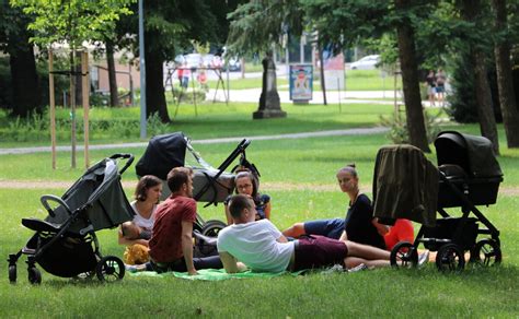 rodina s detským kočíkom v mestskom parku