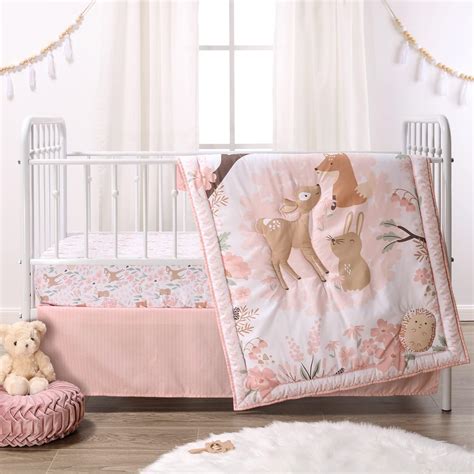 baby with a comforter in a crib
