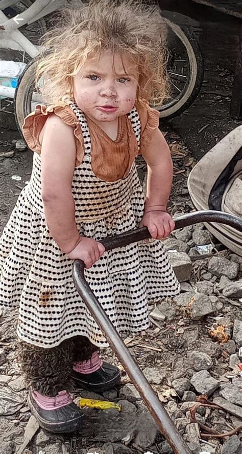 Dieťa s prekríženými nohami, ktoré sa hanbí za svoje topánky